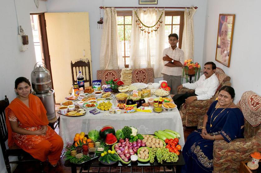 IND04.0001.xxf1rw (MODEL RELEASED IMAGE) The Patkar family—Jayant, 48, Sangeeta, 42, daughter Neha, 19, and son Akshay, 15—in the living room of their home in Ujjain, Madhya Pradesh, India, with one week’s worth of food. Cooking method: gas stove. Food preservation: refrigerator-freezer. /// The Patkar family is one of the thirty families featured in the book Hungry Planet: What the World Eats (p. 166). Food expenditure for one week: $39.27 USD. (Please refer to Hungry Planet book p. 167 for the family’s detailed food list.)